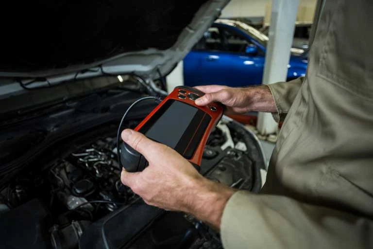 hands mechanic using diagnostic tool scaled